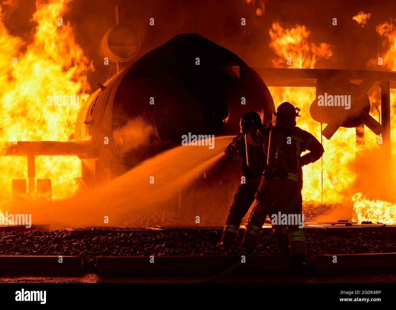 I vigili del fuoco con le forze armate nazionali lettoni e le forze di difesa estoni usano un tubo flessibile per spegnere un incendio aereo simulato al Centro di addestramento di preparazione del combattimento di Alpena, Michigan, 12 agosto 2021. La simulazione faceva parte del Northern Strike 21-2, un esercizio sponsorizzato dal National Guard Bureau, un produttore di preparazione su misura che ha riunito 5,100 partecipanti provenienti da vari stati e paesi al National All-Domain Warfighting Center. (STATI UNITI Air National Guard foto di staff Sgt. Valentina Viglianco) Foto Stock