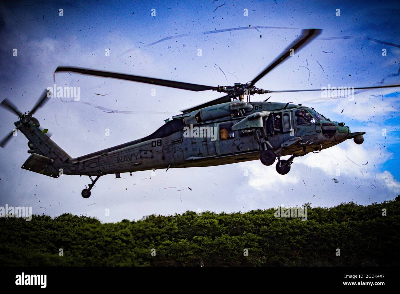 210803-N-MO469-1025 SANTA RITA, Guam (agosto 3, 2021) l'equipaggio assegnato all'HSC-25 atterra un MH-60S su un pattino di atterraggio prototipo costruito da Seabees assegnato a Naval Mobile Construction Battaglione (NMCB) 11 Det. Guam. Il pianerottolo è stato costruito mentre supportava III MEF utilizzando un sistema di applicazioni biocemente sviluppato da bioMASON con il supporto della Defense Advanced Research Projects Agency. Il sistema di applicazione biocemento è progettato per essere utilizzato in posizioni operative in avanti su superfici native non ingegnerizzate per rafforzare il terreno, promuovere il controllo dell'erosione e aumentare il disbimento della polvere migliorando exdi Foto Stock