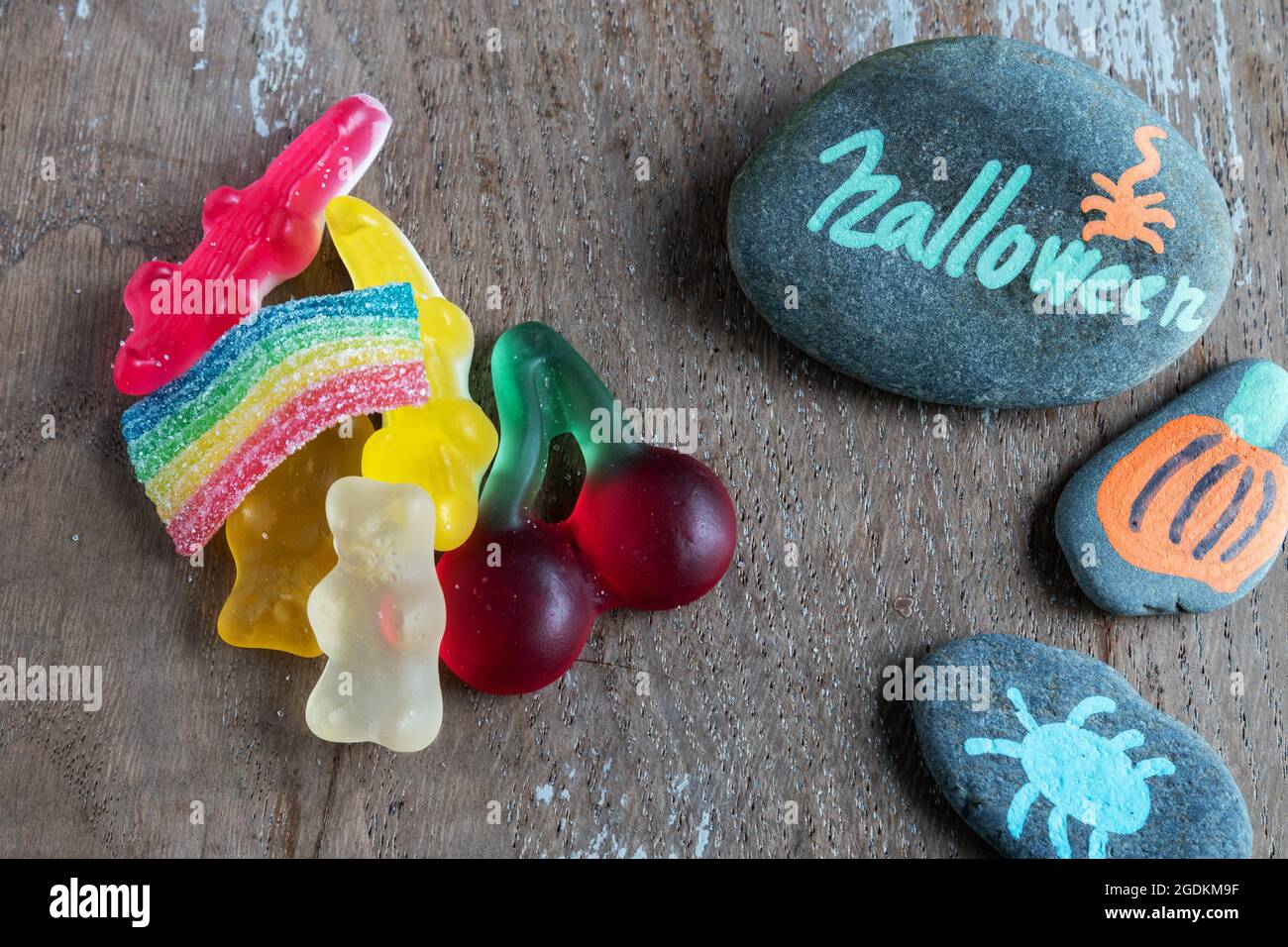 Sfondo in legno con pietre e treats dipinti di Halloween Foto Stock