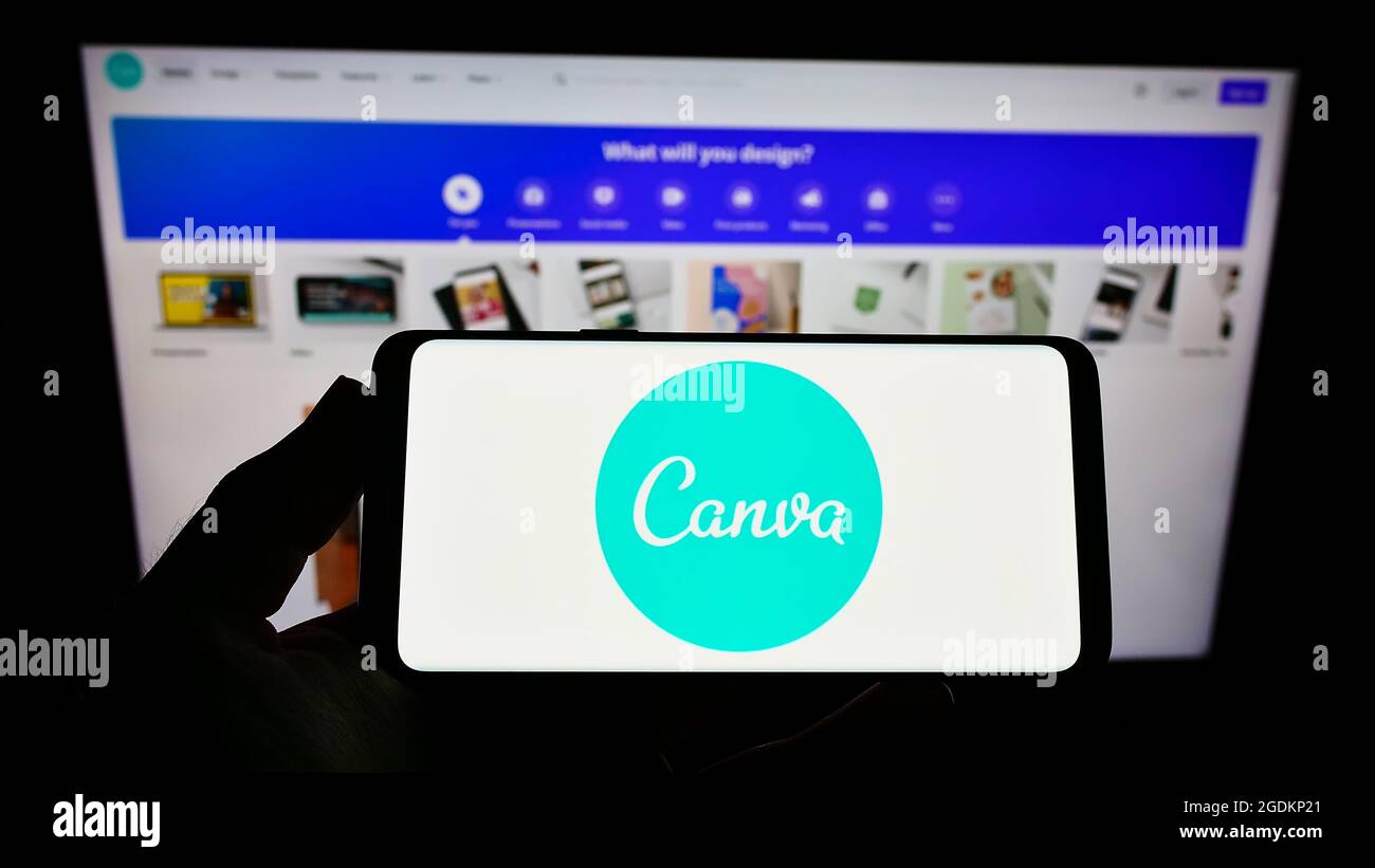 Persona che tiene il telefono mobile con il logo della società australiana di disegno grafico Canva Pty Ltd sullo schermo davanti alla pagina web. Mettere a fuoco il display del telefono. Foto Stock