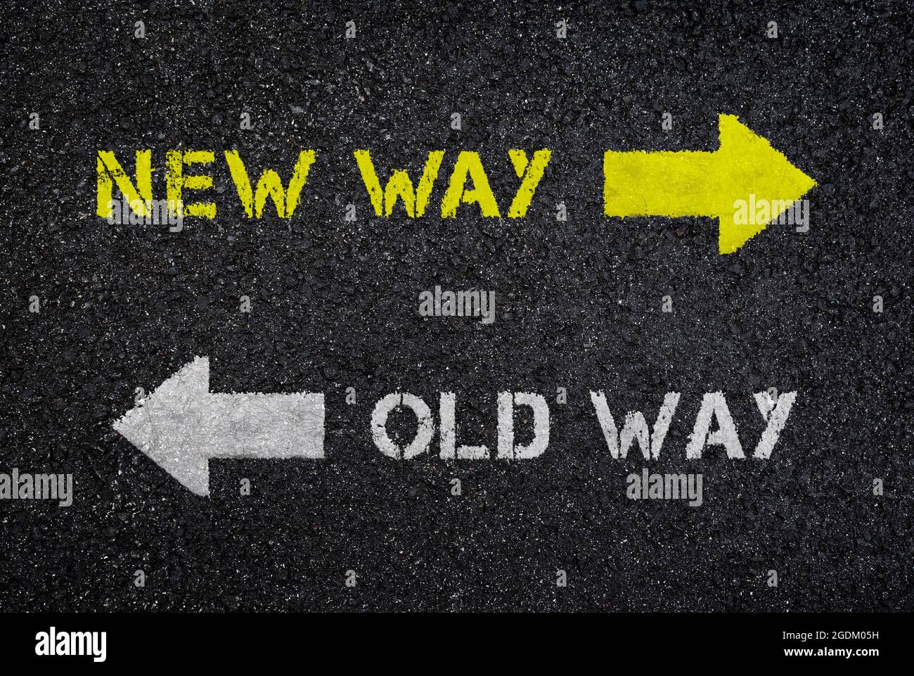 Cartelli/testi "New Way" e "Old Way" con frecce che puntano in direzioni opposte su strade asfaltate nere scure e bagnate, vista dall'alto. Sfondo con texture. Foto Stock