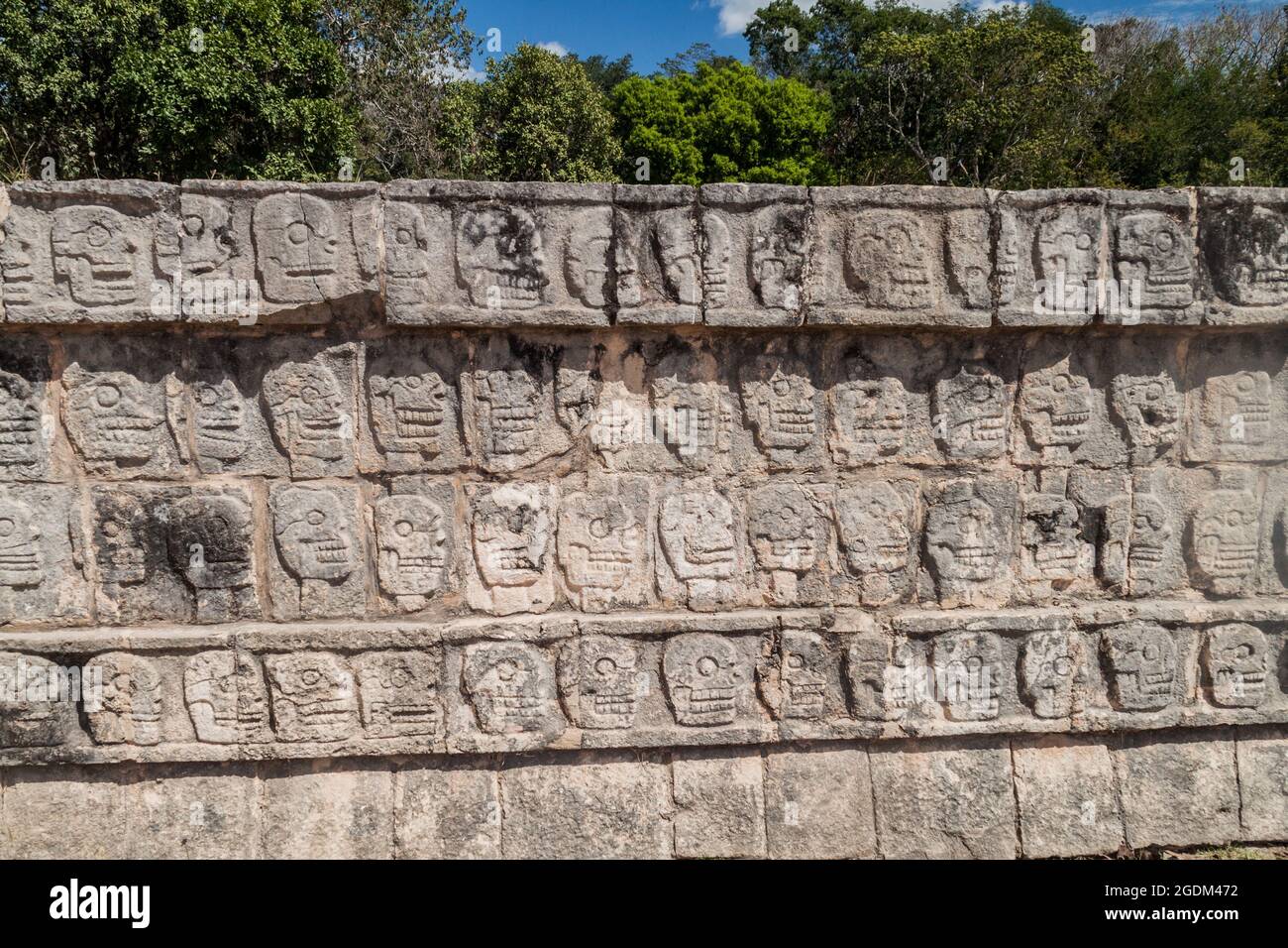 Teschi scolpiti alla piattaforma di teschi presso il sito archeologico Chichen Itza, Messico Foto Stock