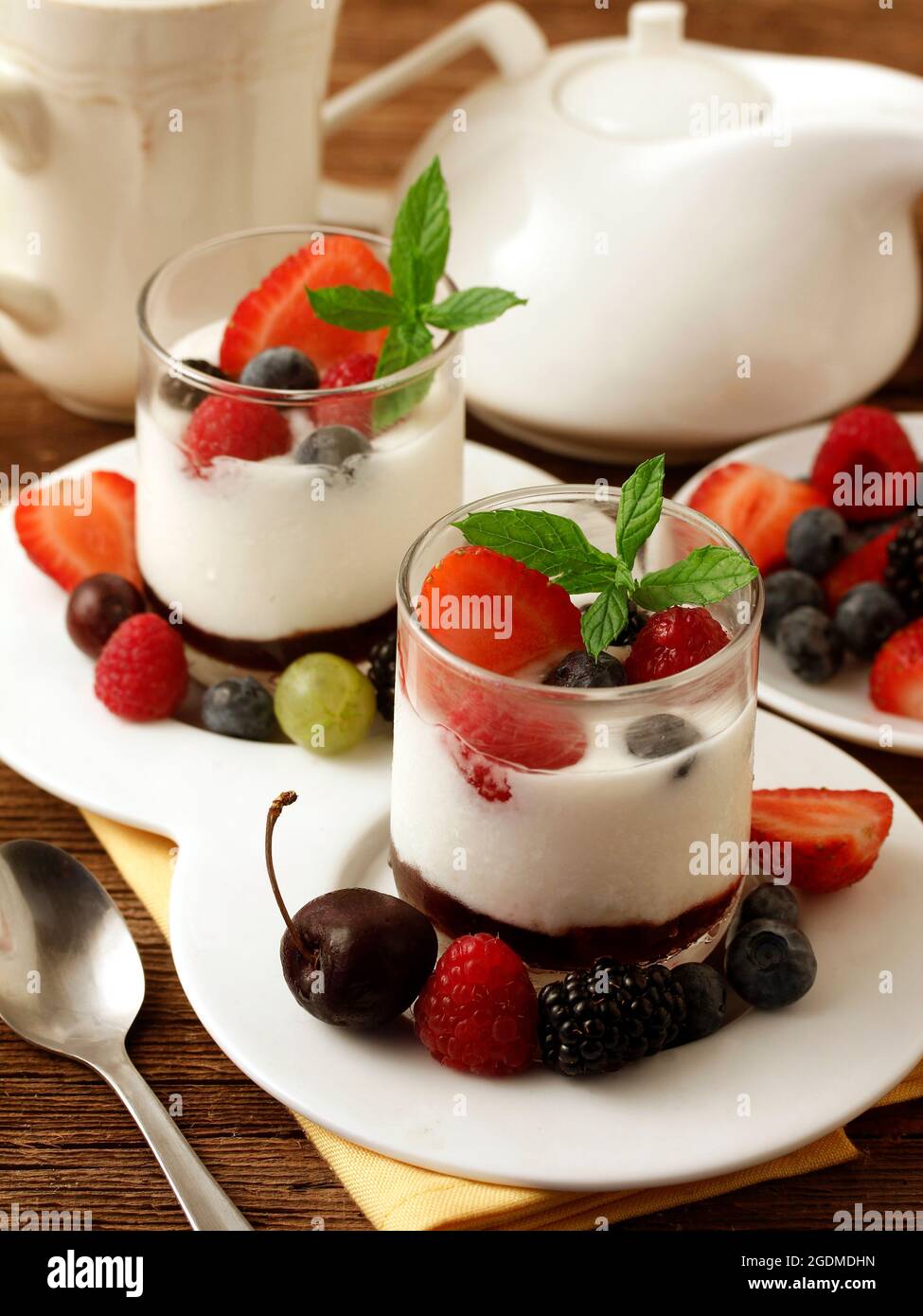 Yogurt con frutti di bosco. Ciliegie, lamponi, more, mirtilli, frutti di bosco, fragole. Foto Stock