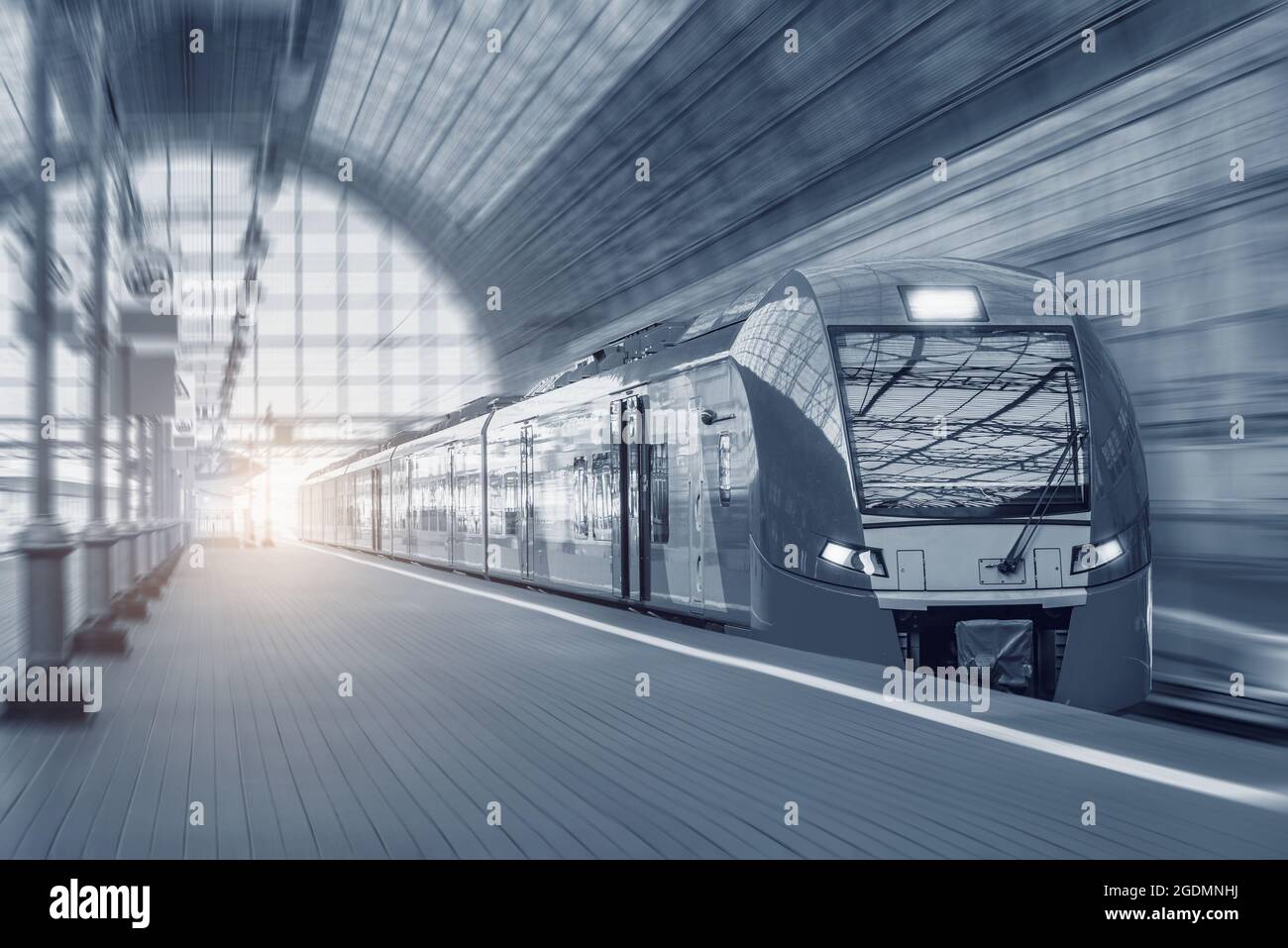 Il treno ad alta velocità si muove velocemente lungo la piattaforma al tramonto. Foto Stock
