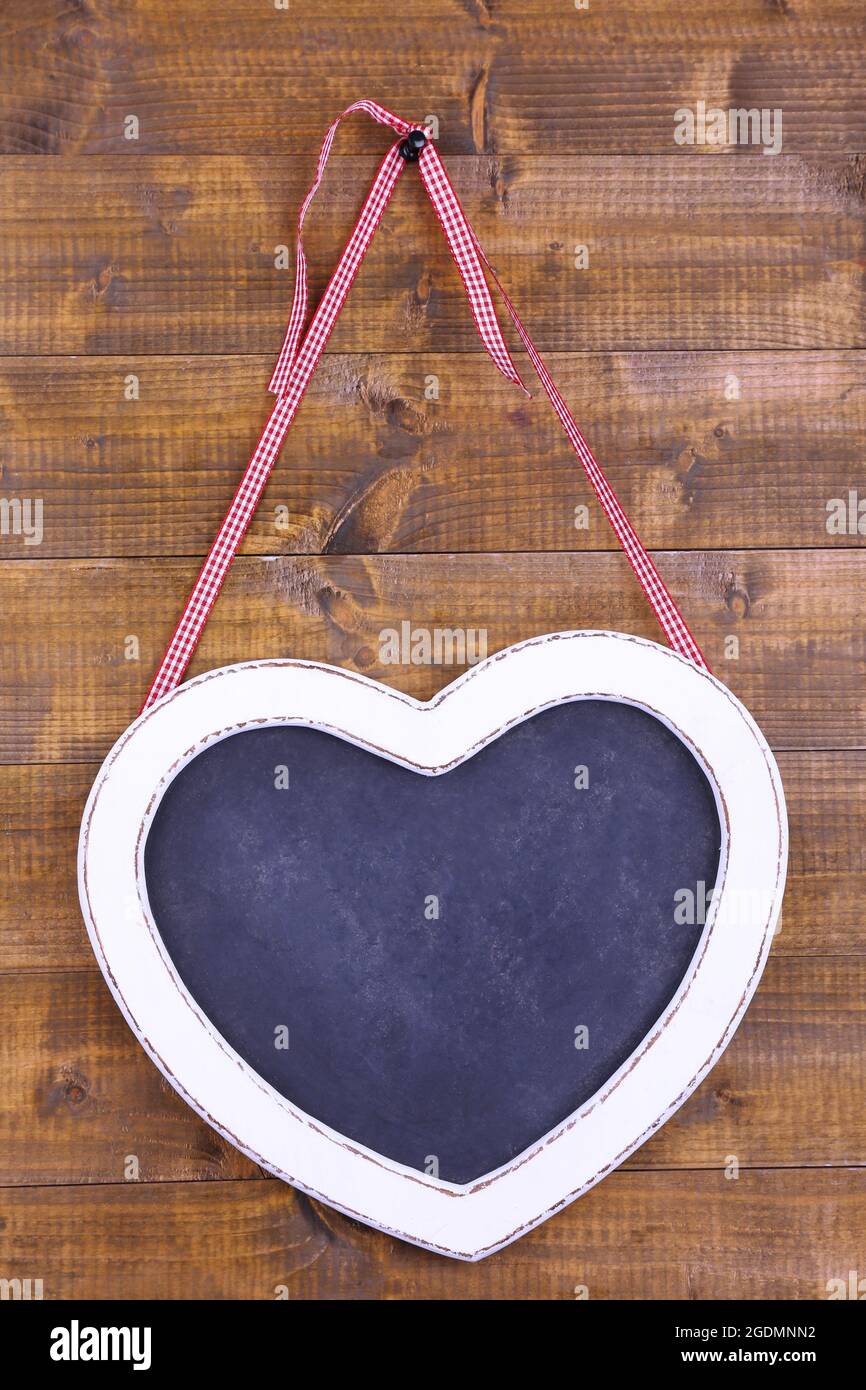 Lavagna a forma di cuore su sfondo di legno Foto stock - Alamy