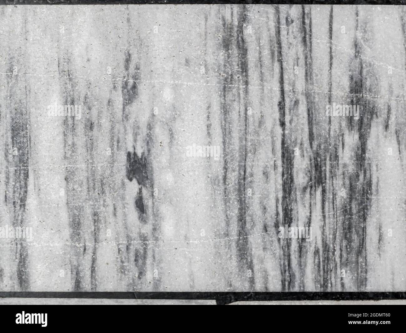 Vista dall'alto del vecchio pavimento, fatto di pezzi di varie dimensioni in marmo bianco e grigio. Sfondo a mosaico bianco e nero astratto. Foto Stock