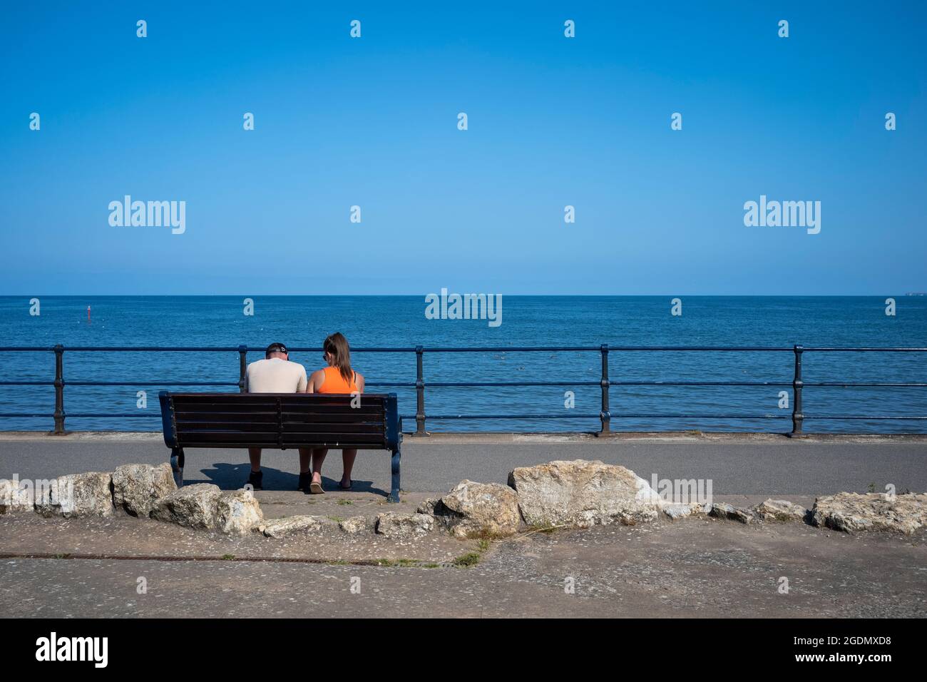 Una coppia su una panchina di mare, Filey, North Yorkshire, Regno Unito Foto Stock