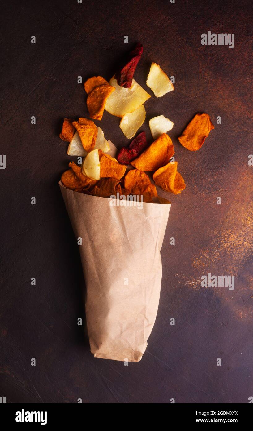 Patatine di verdure a base di patate, carote e barbabietole sparse in un sacchetto di kraft Foto Stock