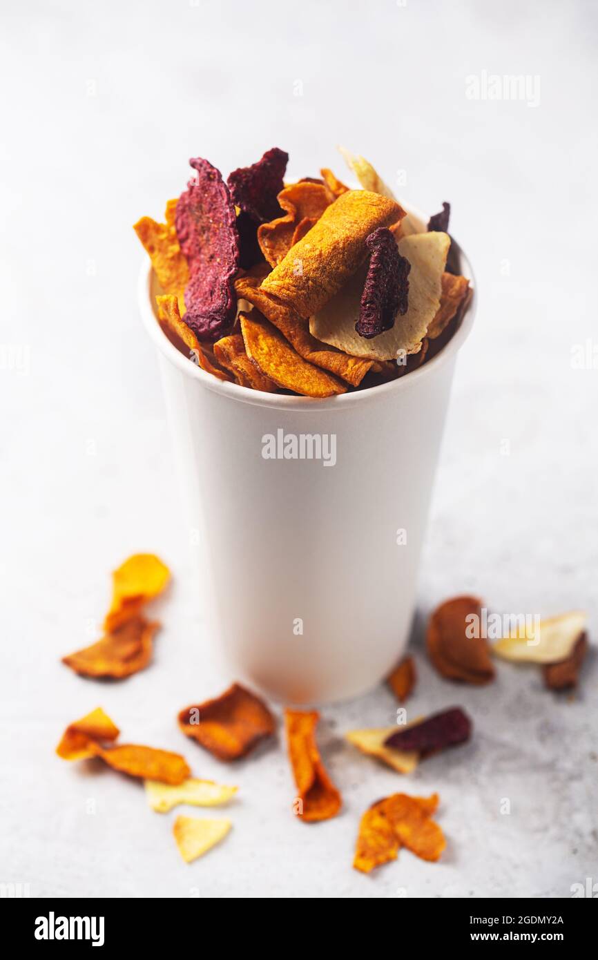 Patata biologica vegetale, patatine di barbabietola e carote in un bicchiere bianco per spuntini Foto Stock