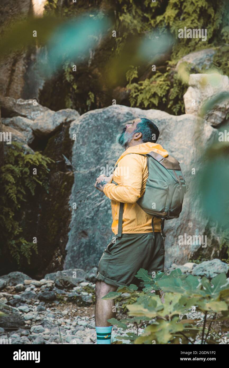 Uomo che guarda in su stupito nella foresta Foto Stock