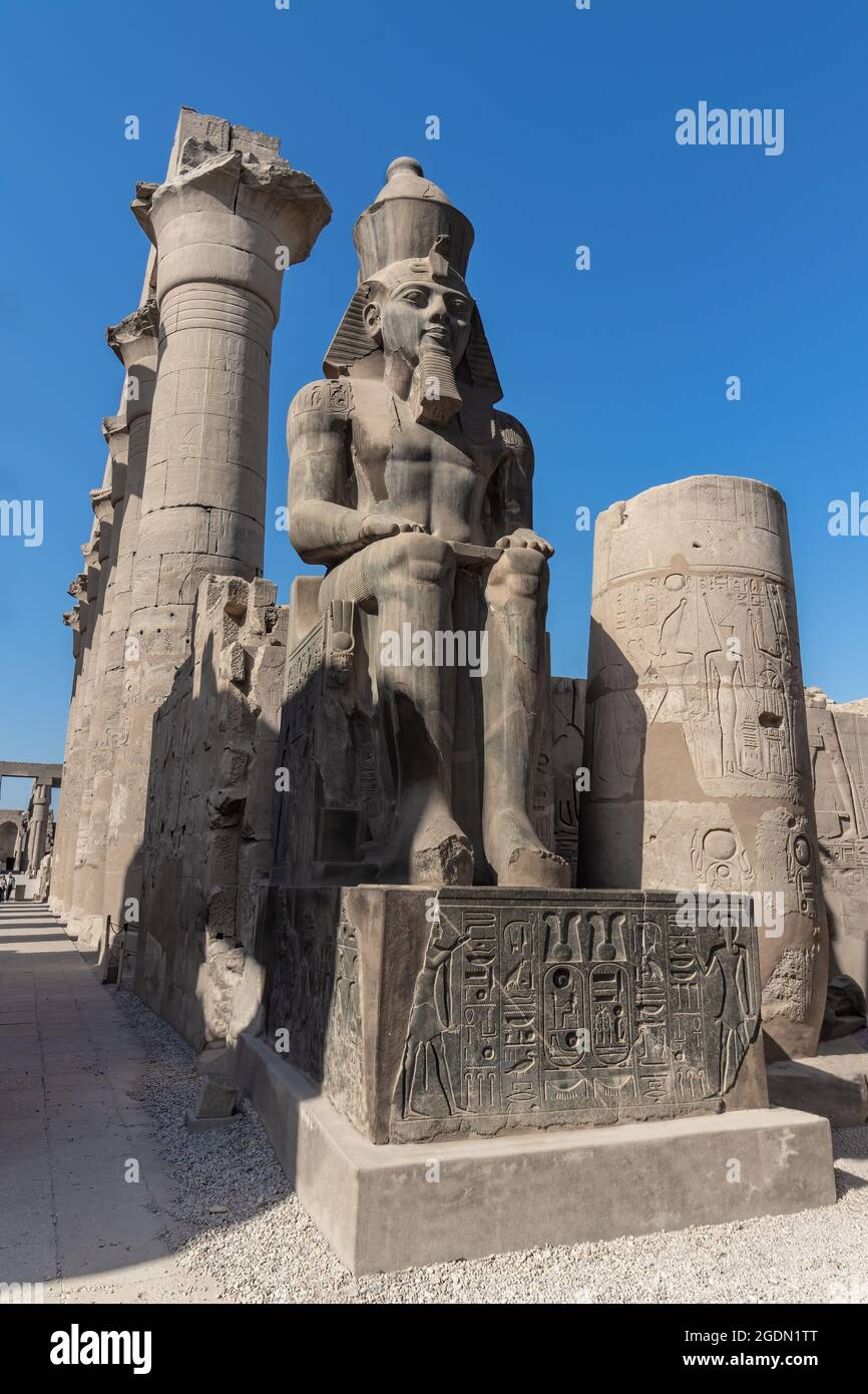 La gigantesca statua di Ramesse II nel Tempio di Luxor, Egitto, un antico e grande tempio egizio complesso situato sulla riva est del fiume Nilo in città Foto Stock