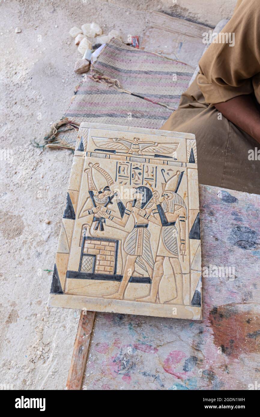 Artigiano che lavora su una riproduzione di una tavoletta con geroglifici egiziani a Luxor, Egitto Foto Stock