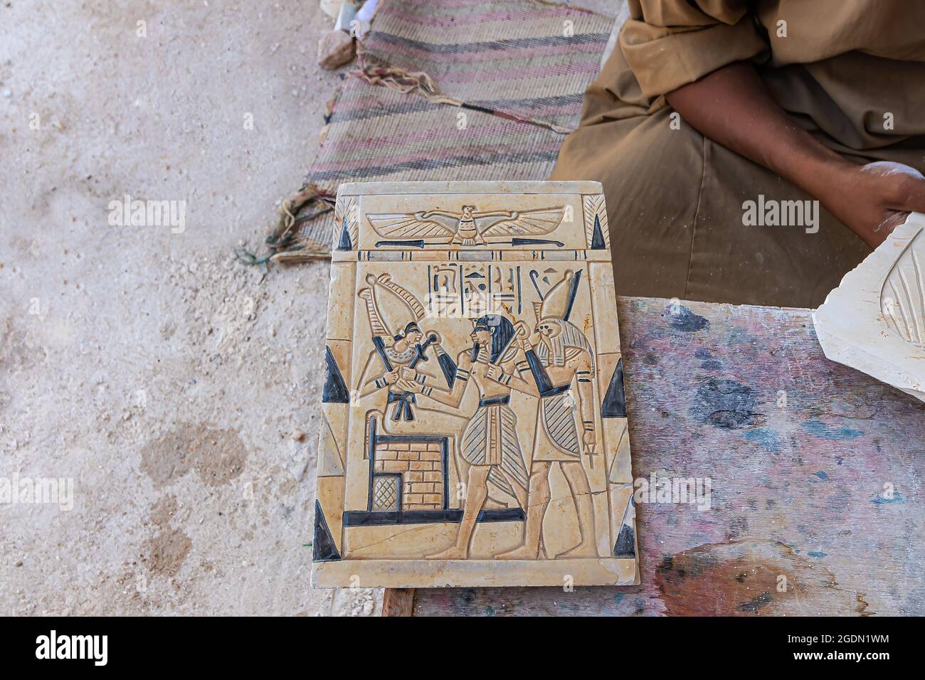 Artigiano che lavora su una riproduzione di una tavoletta con geroglifici egiziani a Luxor, Egitto Foto Stock