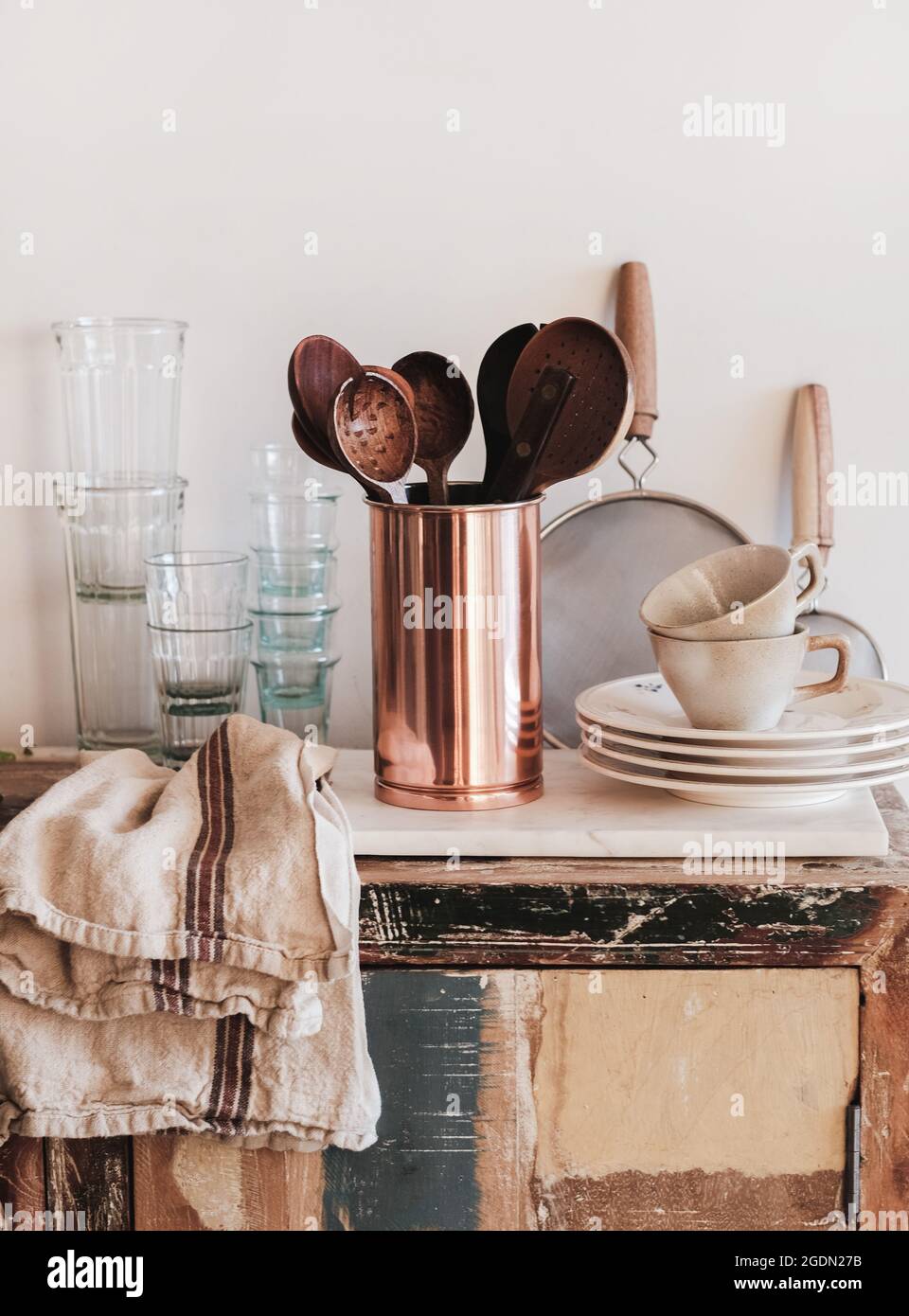 Utensili da cucina, vetreria e stoviglie su un piano cucina rustico Foto Stock