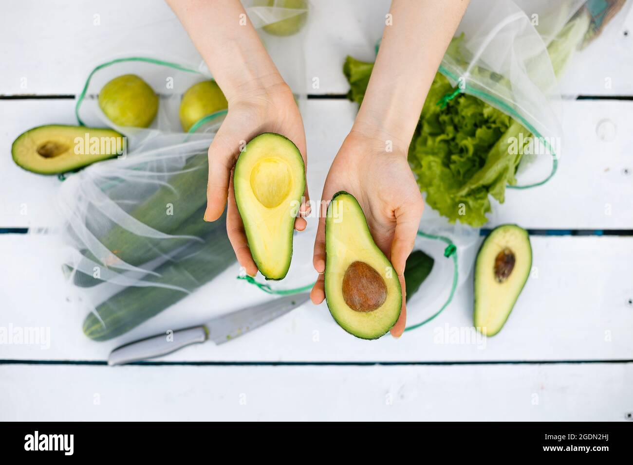 Vista dall'alto di due parti di avocado in mano Foto Stock