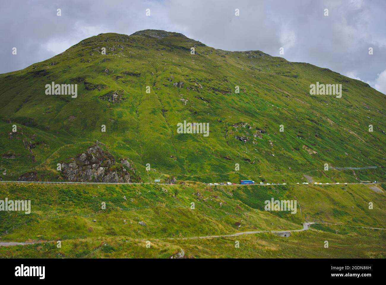 Traffico lento sulla A83 sopra la vecchia strada militare di General Wade e sotto Beinn IME, la più alta delle Alpi Arrochar, Argyll e Bute, Scozia, Regno Unito. Foto Stock