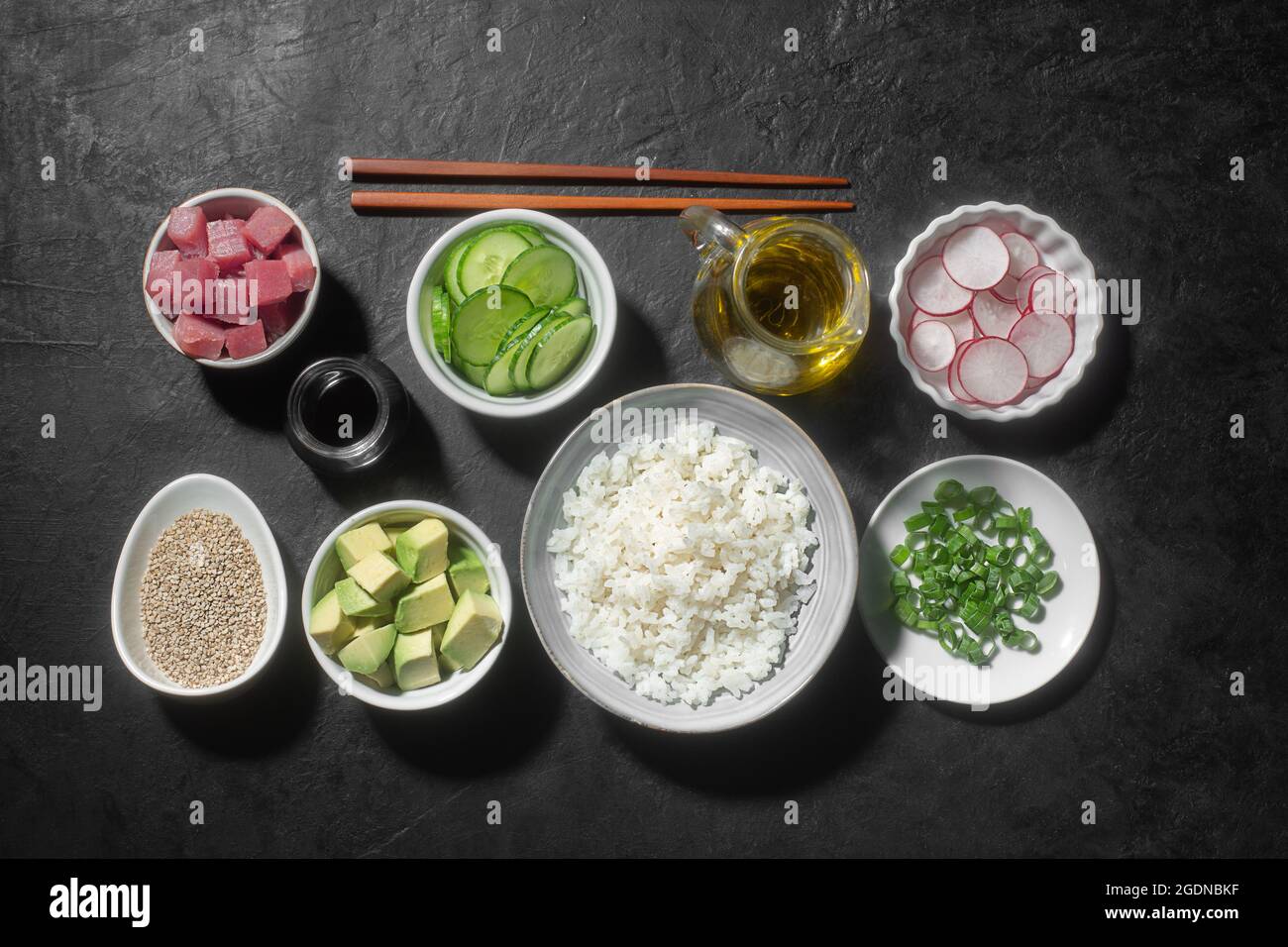 Tradizionale Poke Bowl hawaiano preparato con pesce tonno, riso e verdure, sfondo nero Foto Stock