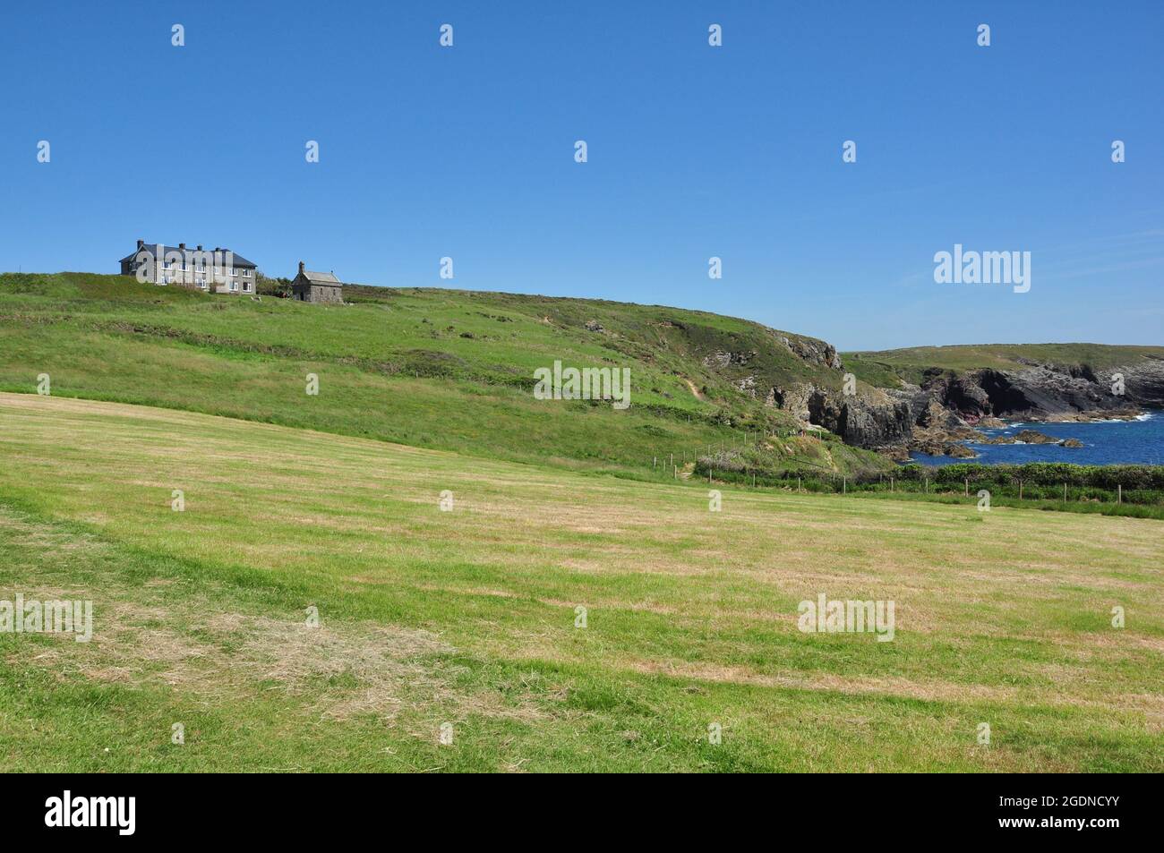 Campi intorno a St non's Bay con St non's Chapel e Retreat Center in cima alla collina, Pembrokeshire, Galles, Regno Unito Foto Stock