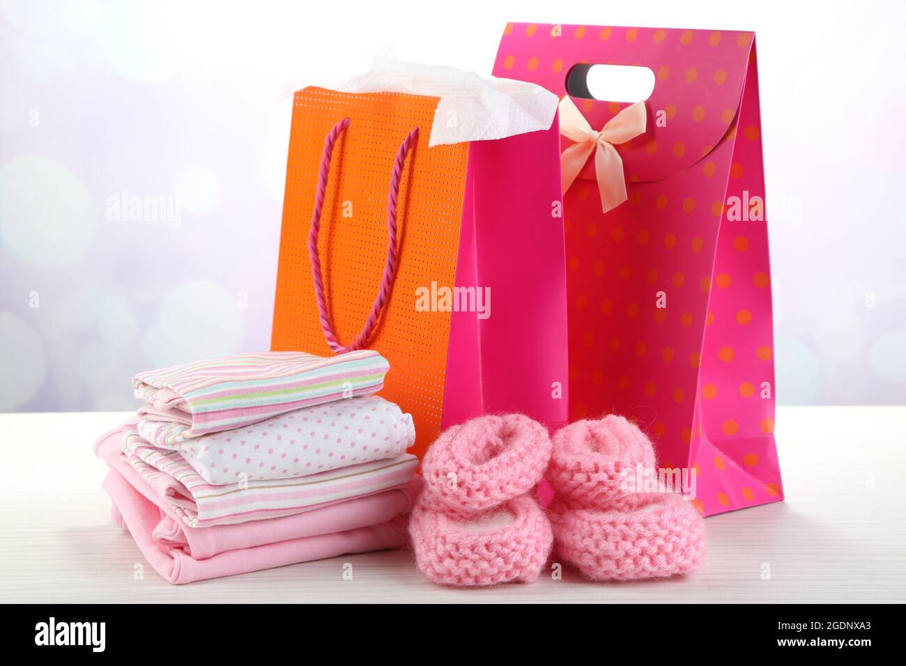 Vestiti del bambino e buste regalo su sfondo lucido Foto stock - Alamy