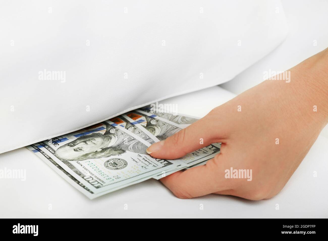 Donna nascondere i soldi sotto il cuscino a casa Foto stock - Alamy