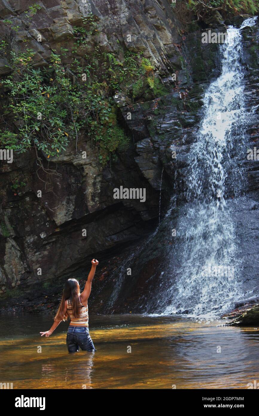 Una giovane ragazza che si gode la cascata di acqua fresca di sorgente nel North Carolina. Un ottimo posto per rilassarsi Foto Stock