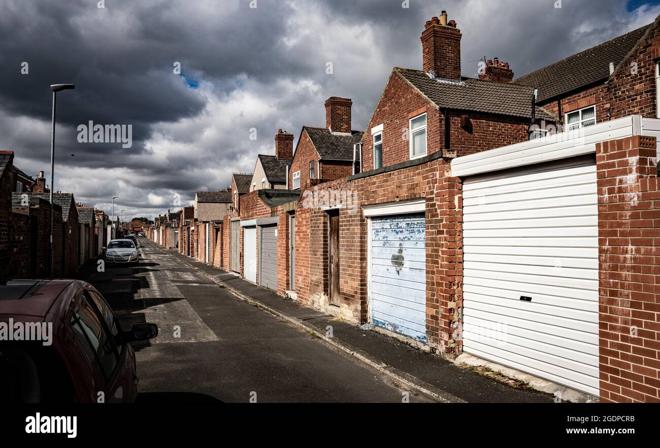 Via posteriore di abitazioni terrazzate ad Ashington, Northumberland, una città mineraria post-industriale nel nord dell'Inghilterra. Foto Stock
