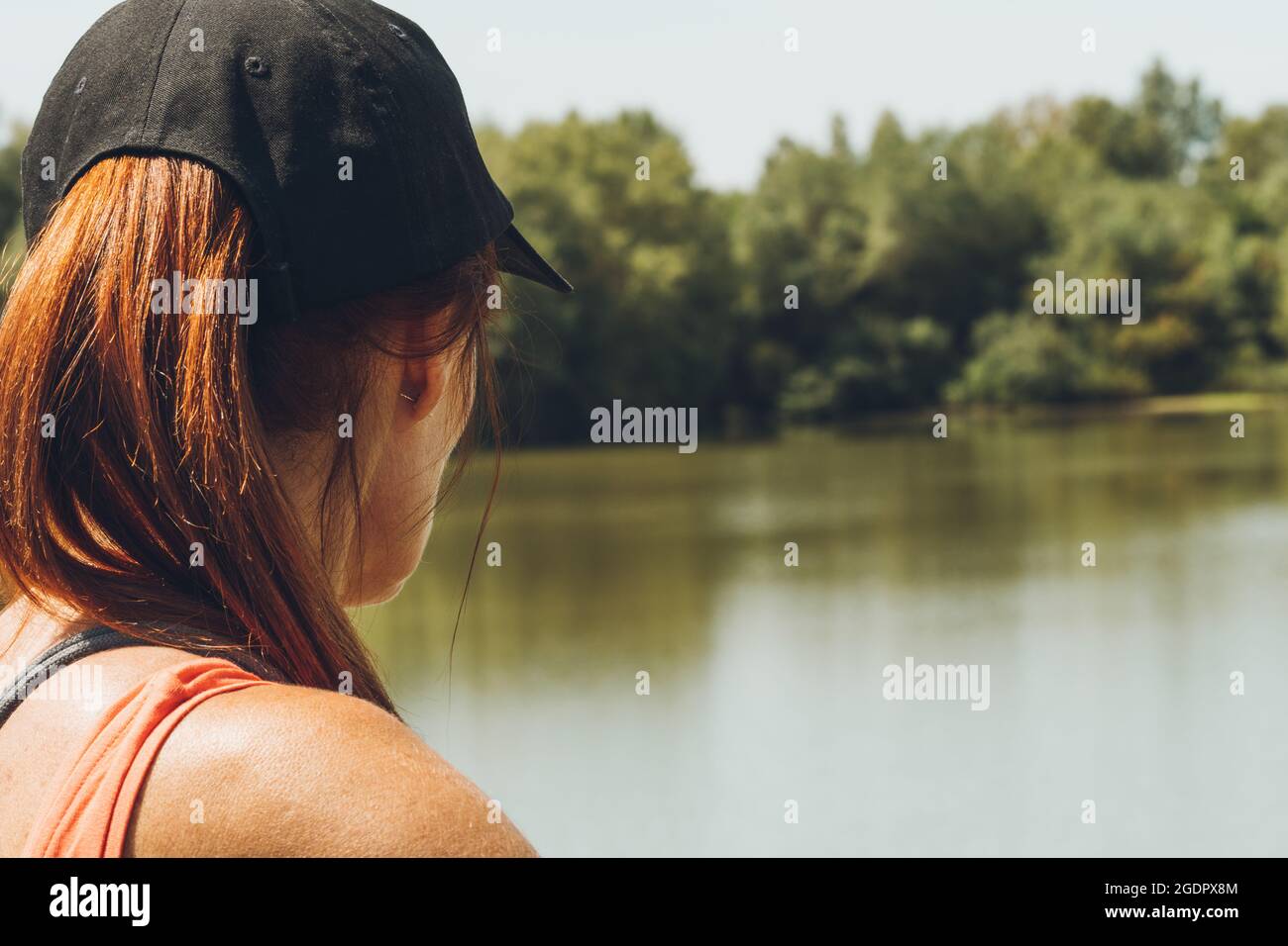 Donna in un cappello che guarda il fiume e il paesaggio Foto Stock