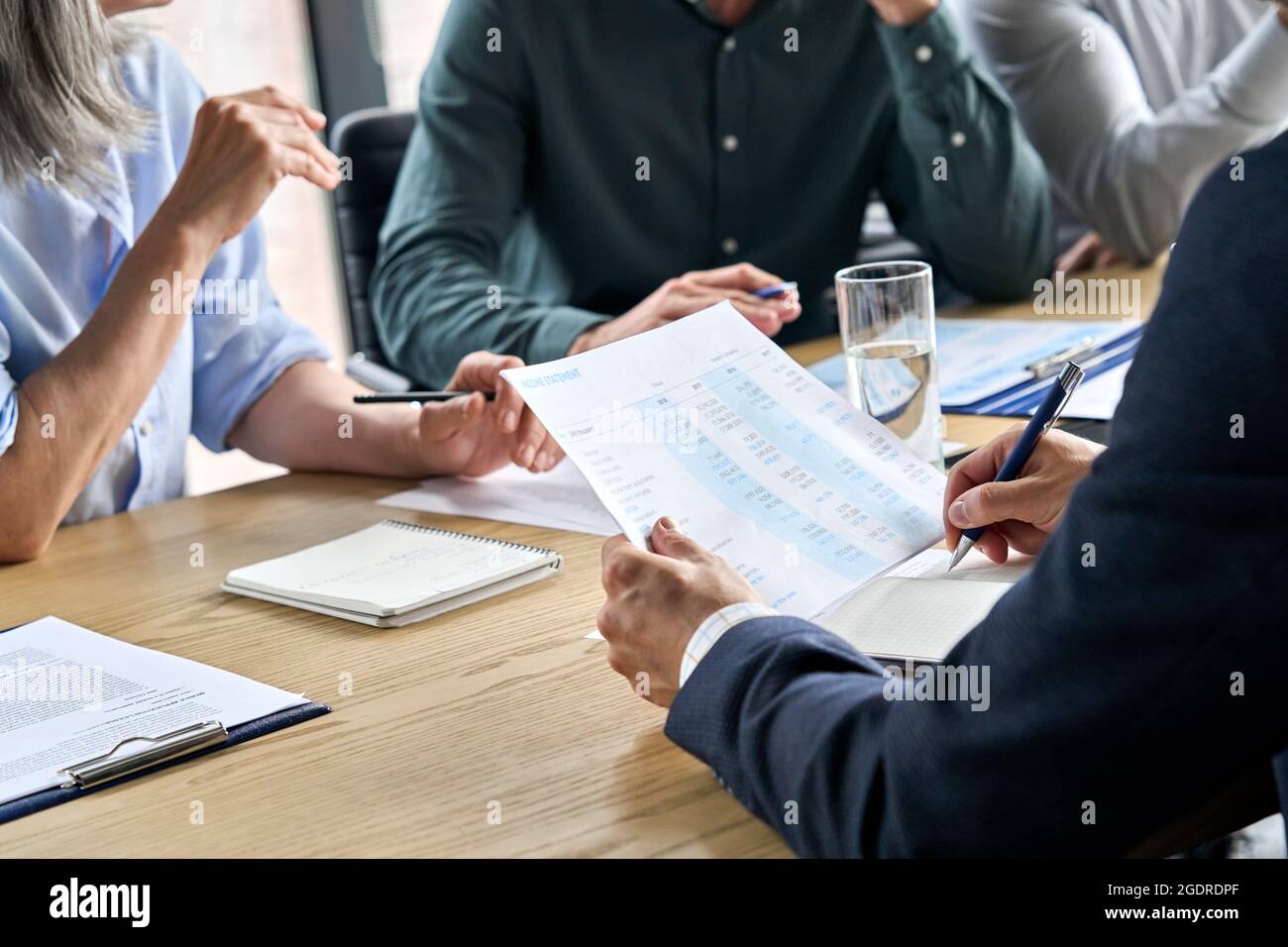 Closeup mani maschili prendere appunti nel rapporto finanziario alla riunione del tavolo. Foto Stock