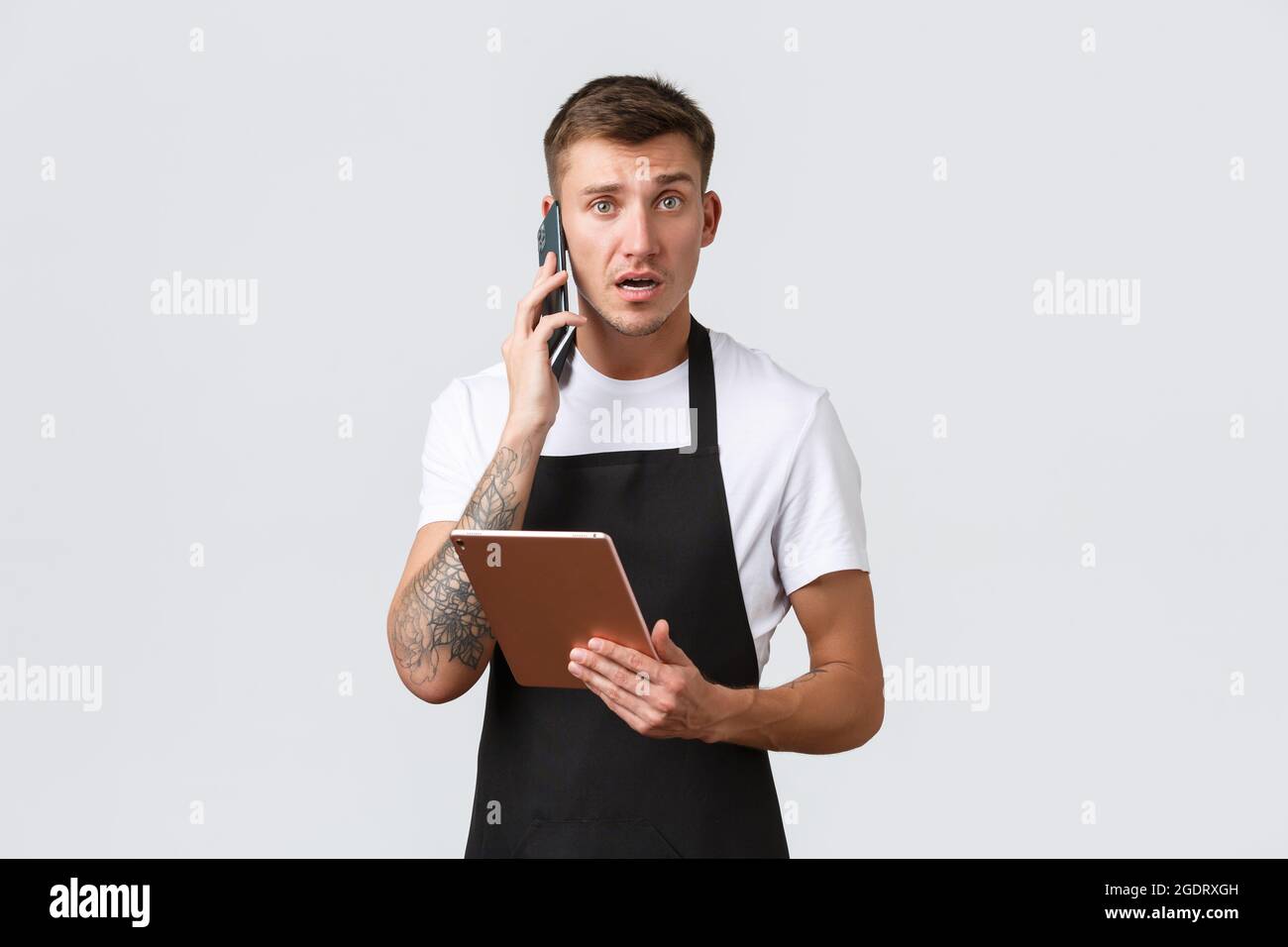 Negozi al dettaglio, piccole aziende, caffè e ristoranti concetto di takeaway. Confuso e preoccupato, il venditore incerto riceve un reclamo dal cliente per telefono Foto Stock