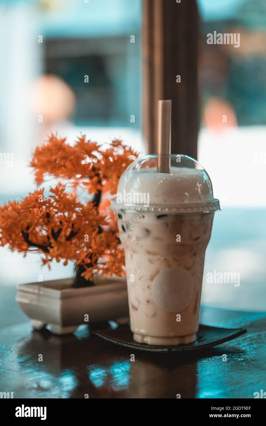Tè al latte ghiacciato con albero di bonsai artificiale in un caffè in stile giapponese Foto Stock