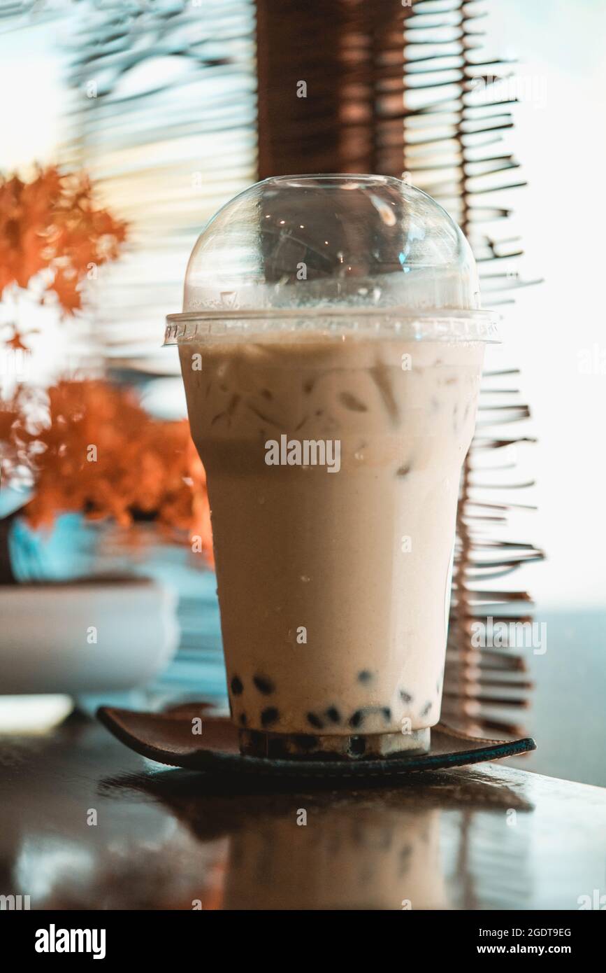 Tè al latte ghiacciato con albero di bonsai artificiale in un caffè in stile giapponese Foto Stock