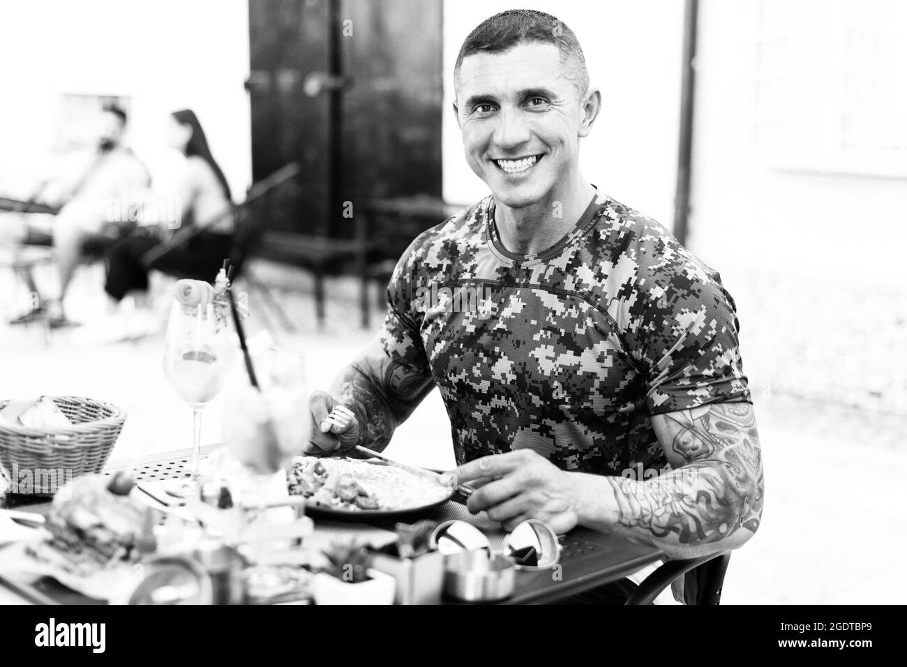 Ritratto di un uomo adulto che mangia Omelet o uova strapazzate all'aperto al ristorante e cocktail Foto Stock