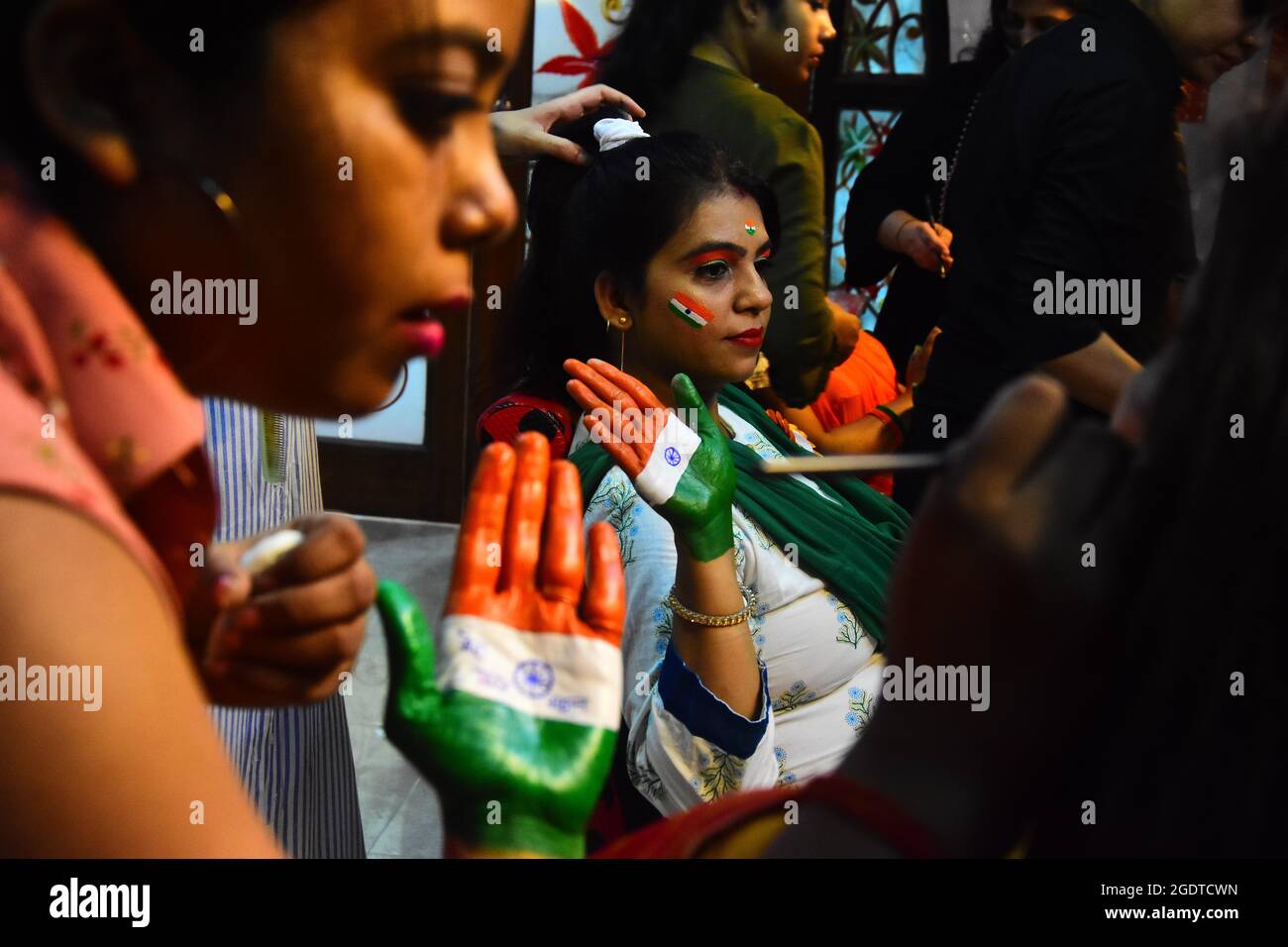 Le donne indiane dipingono i loro volti con messaggi sociali e i colori del tricolore nazionale durante la celebrazione del giorno dell'indipendenza a Jabalpur. Foto Stock