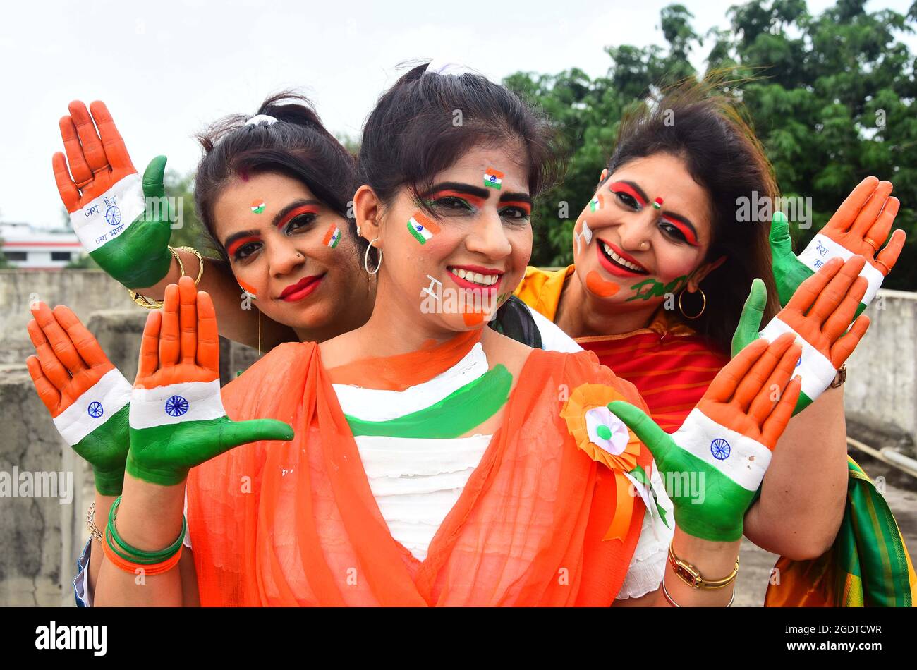 Le donne indiane dipingono i loro volti con messaggi sociali e i colori del tricolore nazionale durante la celebrazione del giorno dell'indipendenza a Jabalpur. Foto Stock