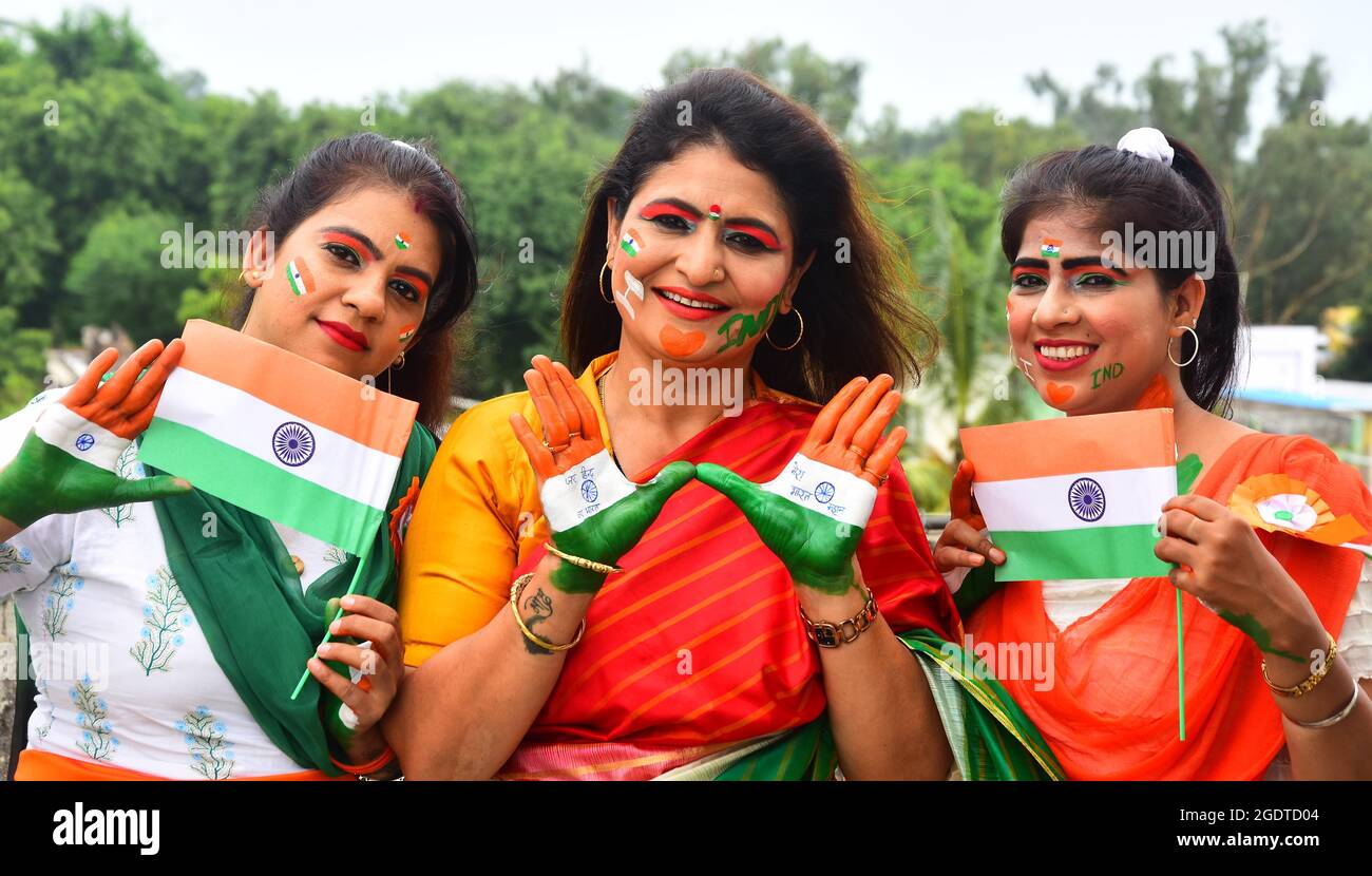 Le donne indiane dipingono i loro volti con messaggi sociali e i colori del tricolore nazionale durante la celebrazione del giorno dell'indipendenza a Jabalpur. Foto Stock