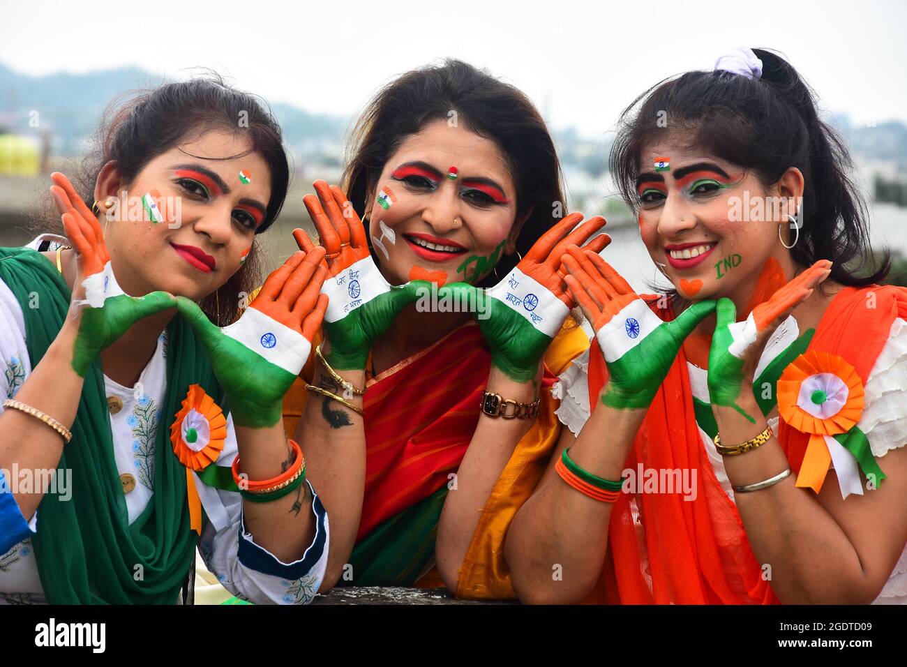 Le donne indiane dipingono i loro volti con messaggi sociali e i colori del tricolore nazionale durante la celebrazione del giorno dell'indipendenza a Jabalpur. Foto Stock