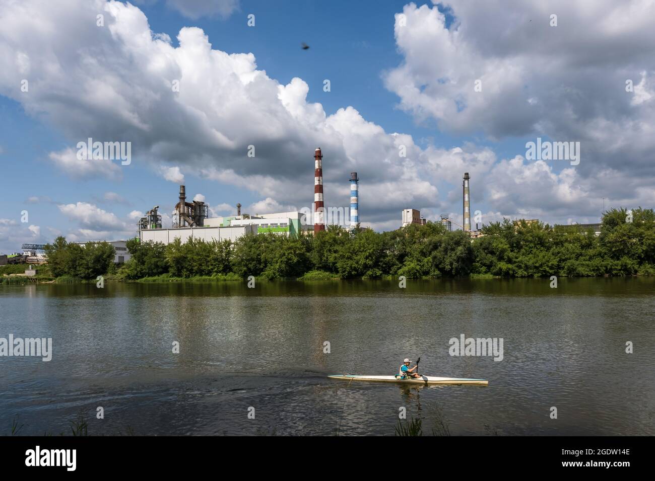 tubi di legno impresa segheria pianta vicino fiume. Concetto di inquinamento dell'aria. Paesaggio industriale inquinamento ambientale spreco di energia termica p Foto Stock