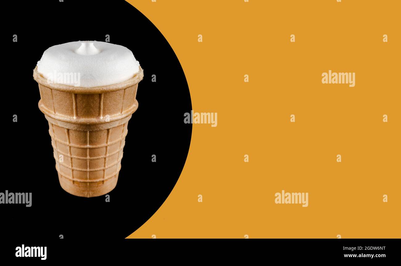 gelato in una tazza di waffle, su sfondo nero, spazio per il testo, su sfondo arancione Foto Stock