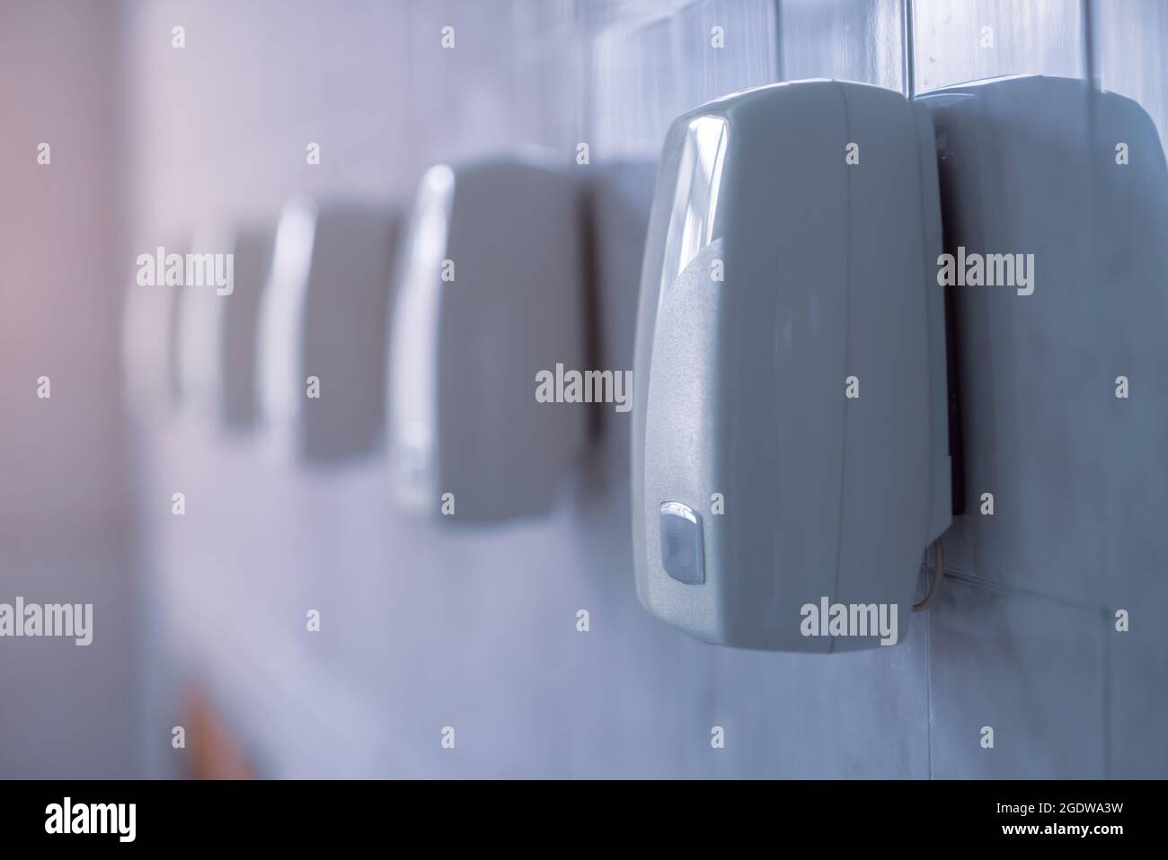 Asciuga mano. Una fila di essiccatori automatici è appesa a una parete. Foto Stock