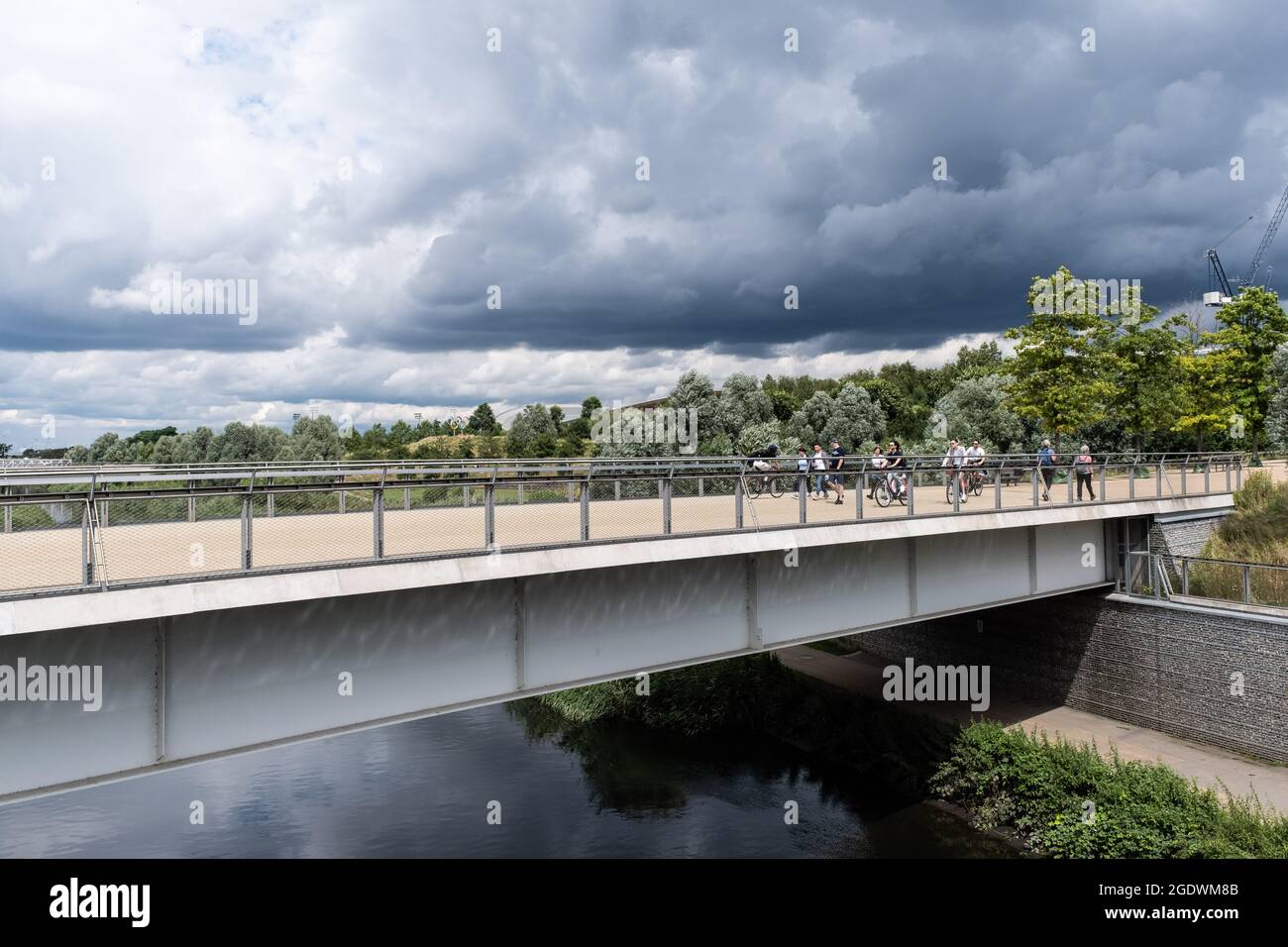 Visitatori su un ponte sul fiume Lea nel Queen Elizabeth Olympic Park, Stratford, Regno Unito Foto Stock