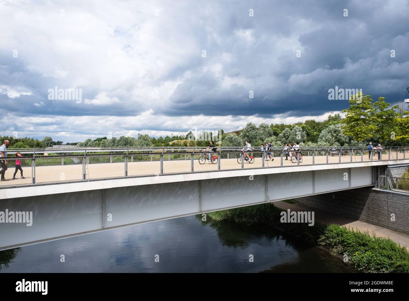 Visitatori su un ponte sul fiume Lea nel Queen Elizabeth Olympic Park, Stratford, Regno Unito Foto Stock