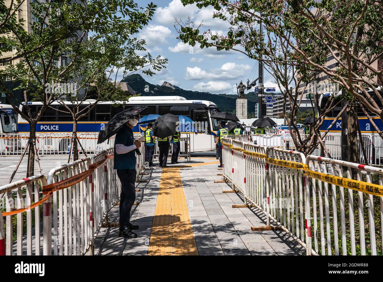 Seoul, Corea del Sud. 15 agosto 2021. Gli ufficiali di polizia si trovano lungo le recinzioni erette a Seoul. La polizia sudcoreana allestisce le mura degli autobus e i punti di controllo per bloccare i manifestanti a Seul. La Corea del Sud ha vietato le proteste prima della Giornata Nazionale di Liberazione, in previsione della ripresa dell’epidemia di coronavirus causata da un raduno anti-governo lo scorso agosto. Credit: SOPA Images Limited/Alamy Live News Foto Stock