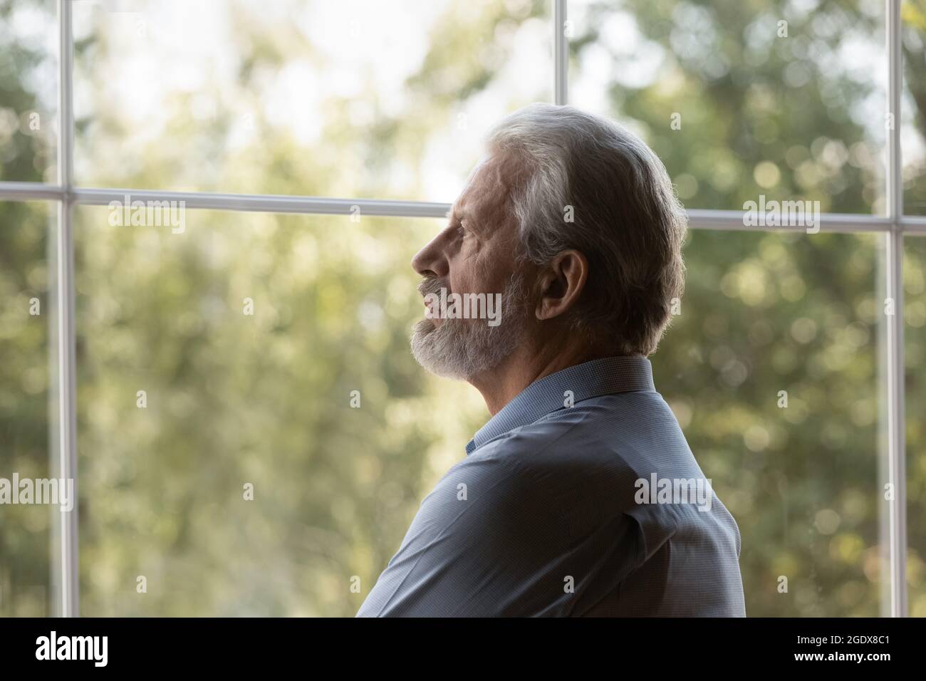 L'uomo anziano sconvolto guarda a distanza sentendosi triste Foto Stock
