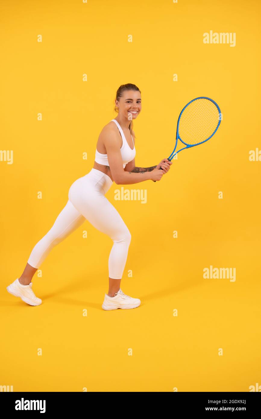 felice giovane ragazza in abbigliamento sportivo running con racchetta. sportiva. donna energica Foto Stock