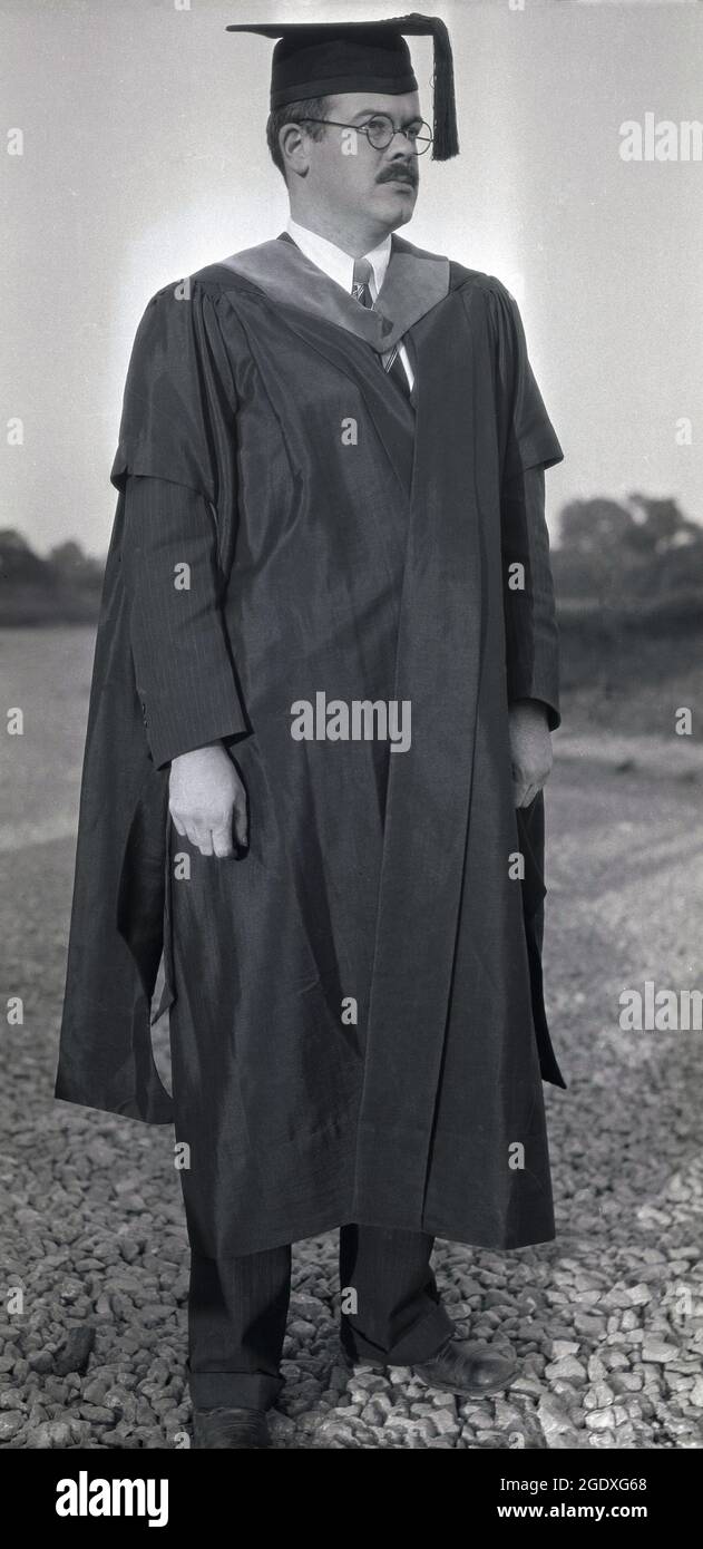 Anni '50, storico, laurea, un maturo maschio laureato in piedi in testa e  abito, Stati Uniti. La tradizione di indossare un cappello - o mortarboard  visto qui - e vestito per la