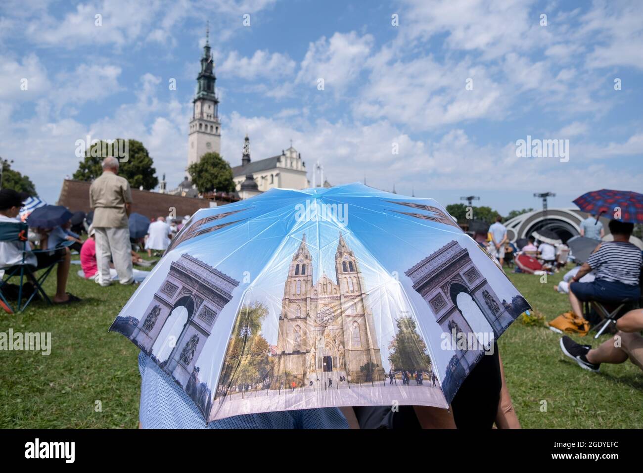 Czestochowa, Polonia. 15 agosto 2021. Un pellegrino si vede coprirsi di un ombrello per proteggersi dal sole di fronte al Monastero di Jasna Gora. Ogni anno in estate migliaia di pellegrini vengono al Monastero di Jasna Gora a Czestochowa per pregare davanti all'immagine della Madonna Nera, la Madre di Dio. Jasna Gora è il più grande santuario della Polonia per tutti i cattolici. (Foto di Wojciech Grabowski/SOPA Images/Sipa USA) Credit: Sipa USA/Alamy Live News Foto Stock