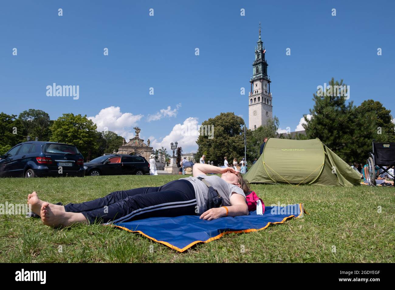 Czestochowa, Polonia. 15 agosto 2021. Una donna è vista sdraiata vicino ad una tenda di fronte al monastero di Jasna Gora. Ogni anno in estate migliaia di pellegrini vengono al Monastero di Jasna Gora a Czestochowa per pregare davanti all'immagine della Madonna Nera, la Madre di Dio. Jasna Gora è il più grande santuario della Polonia per tutti i cattolici. (Foto di Wojciech Grabowski/SOPA Images/Sipa USA) Credit: Sipa USA/Alamy Live News Foto Stock