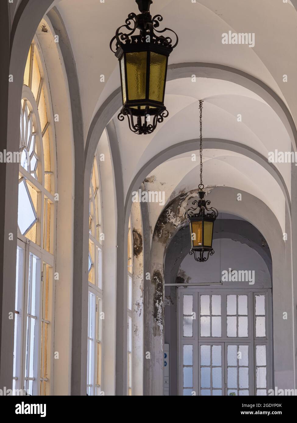 Antichi ed enormi lampadari in ferro e vetro in un corridoio pubblico con  grandi finestre Foto stock - Alamy