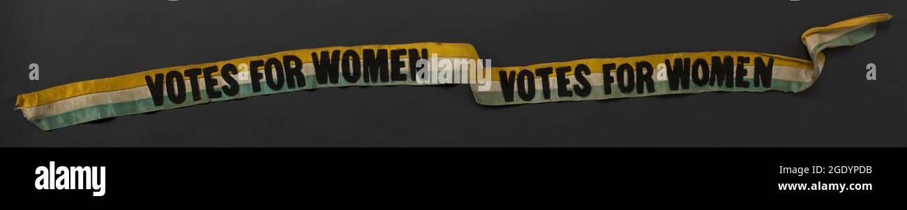 Sash in raso a righe verde, bianco e oro, con due volte 'voti per le donne' in nero, 1914. Foto Stock