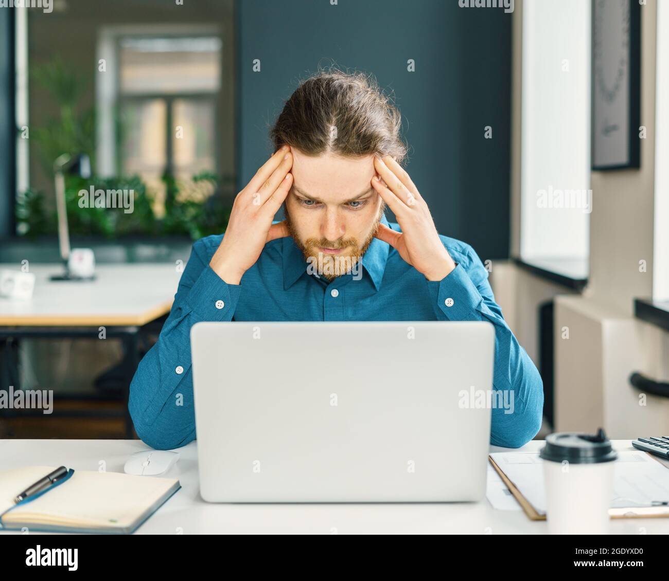 Dipendente aziendale maschile focalizzato che cerca di concentrarsi Foto Stock